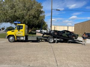 Flatbed Towing Truck Loading Black Camo Sports Car