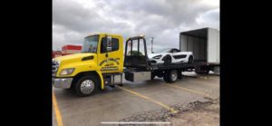 Flatbed Towing Truck Loading White Sports Car Into The Trailer Truck