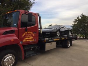 Chavez Towing Truck Carrying A Black Sports Car