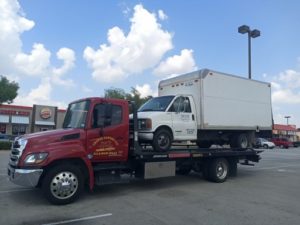 Box Truck In A Red Flatbed Towing Truck