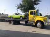 Yellow Flatbed Truck Loaded with Green Car