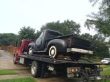 Flatbed Truck Towing An Old Black Vintage Car