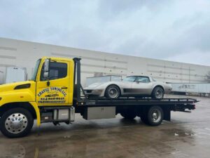 Chavez Towing Truck Loaded With Gray Sports Car