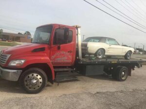 Red Chavez Towing Truck Loaded With White Old Vintage Car