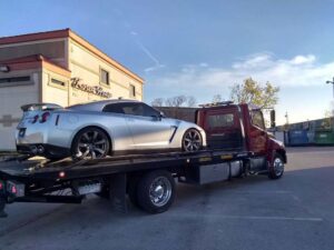 Red Towing Truck Loaded with Silver Sports Car