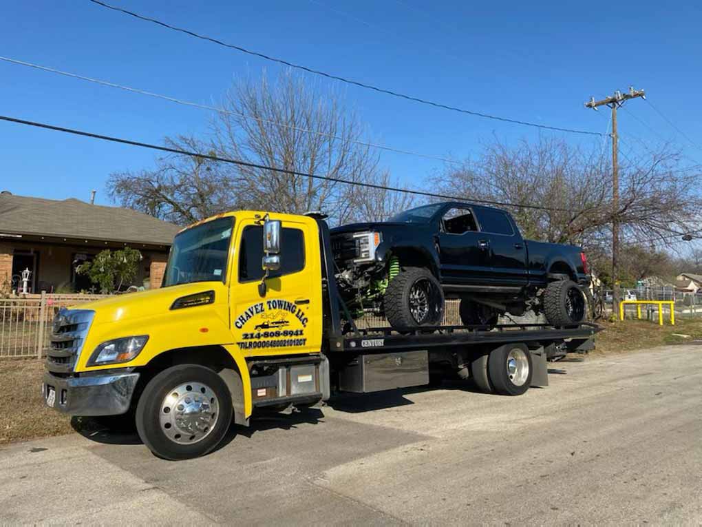 Yellow Chavez Towing Truck Loaded With Big Wheeled-Car