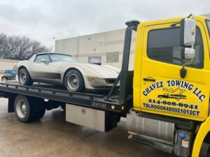 Yellow Chavez Towing Truck Loaded with Gray Sports Car