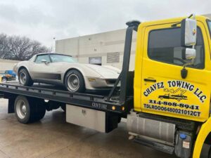 Yellow Chavez Towing Truck Loaded With Gray Sports Car