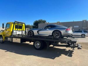 Yellow Towing Truck Loaded With Gray Luxury Car