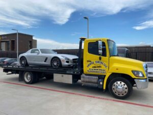 Yellow Towing Truck Loaded With Silver Sports Car